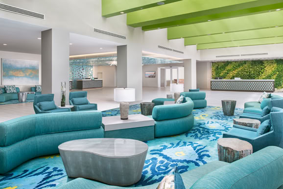Modern resort lobby lounge featuring layered seating, natural light, and contemporary interior design.