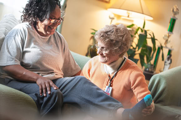 Caregiver assisting patient in a home setting, emphasizing comfort, support, and personal care.